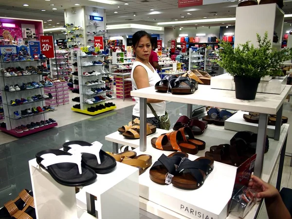 Una donna guarda un paio di scarpe nel reparto scarpe del centro commerciale SM City a Taytay City, Filippine . — Foto Stock