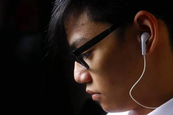 Adolescente usando un teléfono inteligente con un auricular —  Fotos de Stock