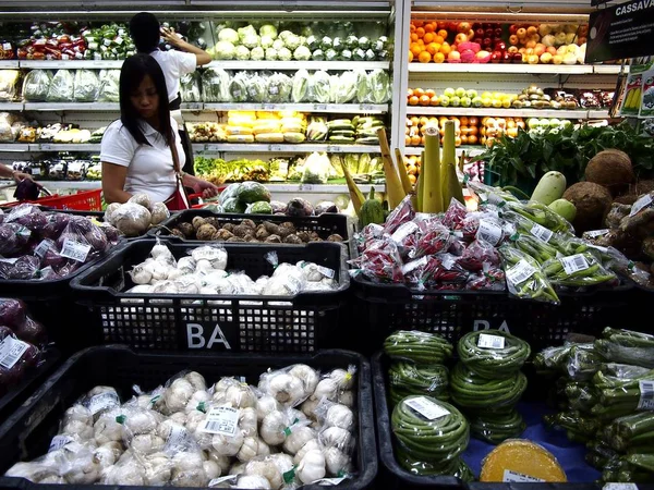 Eine Frau pflückt Obst und Gemüse in einem Lebensmittelgeschäft. — Stockfoto