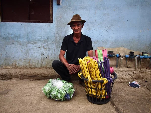 Мужчина продает вешалки для пластиковой одежды на тротуаре вдоль улицы в Антиполо Сити . — стоковое фото