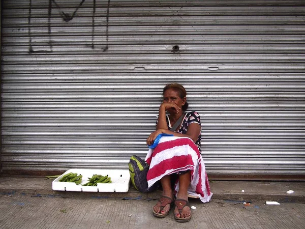 Una mujer vende verduras en una acera a lo largo de una calle en la ciudad de Antipolo . — Foto de Stock