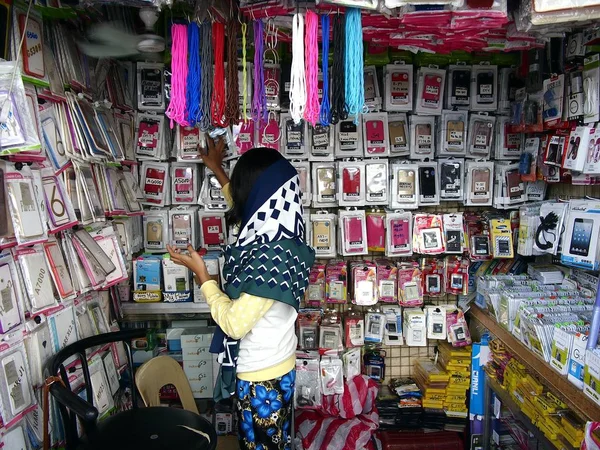 Bir kadın çok çeşitli akıllı telefon ve aksesuarları onun mağazasında satıyor.. — Stok fotoğraf