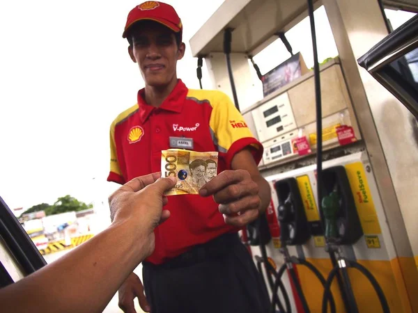 Un benzinaio riceve il pagamento da un cliente . — Foto Stock