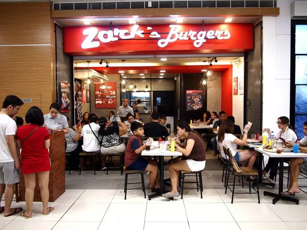 Гості користуватися ними їжі на Zark гамбургери відділення в східному Ортігас торгового центру Sm. — стокове фото
