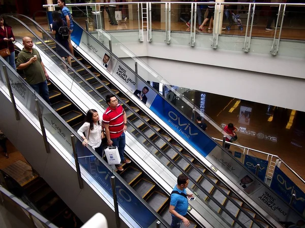 Οι πελάτες χρησιμοποιούν μια κυλιόμενη σκάλα να πάει πάνω και κάτω από ένα εμπορικό κέντρο. — Φωτογραφία Αρχείου
