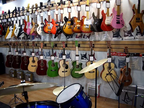 Gitary elektryczne i akustyczne na wystawie sklepu muzycznego. — Zdjęcie stockowe