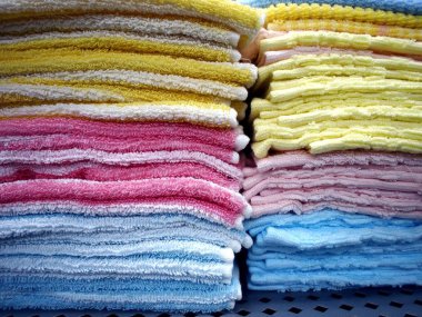 Bir raf üzerinde yığılmış renkli havlu