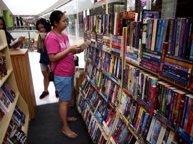 Kitap bir alışveriş mağazasında satışa müşteriler bakmak.