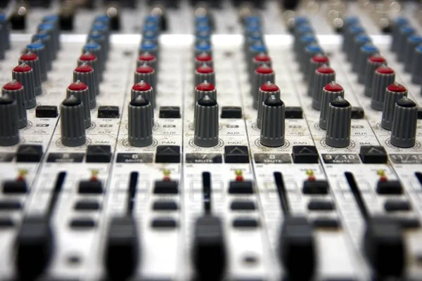 Knobs, sliders and dials on a music or sound mixing console.