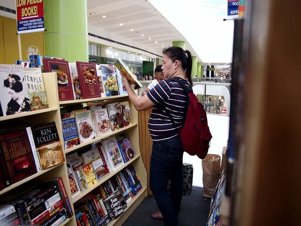 Kitap bir alışveriş mağazasında satışa müşteriler bakmak.