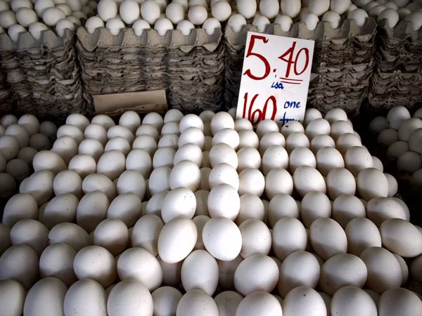 Stacks of trays of eggs on sale at a public market