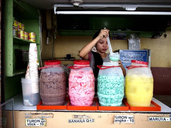 Uma mulher vende bebidas frias variadas em sua loja em um mercado público . — Fotografia de Stock