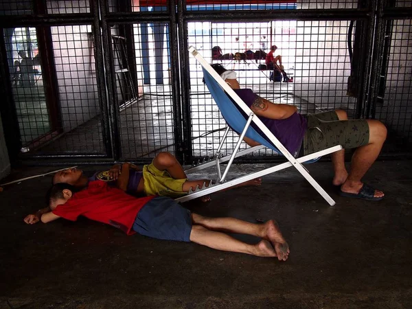 Um homem e um menino dormem no pavimento do lado de fora de um estádio de esportes em Marikina City, Filipinas — Fotografia de Stock