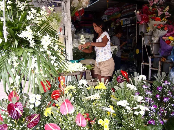 Μια γυναίκα πουλάει πολύχρωμο ανάμεικτα φρέσκα λουλούδια στο κατάστημά της. — Φωτογραφία Αρχείου