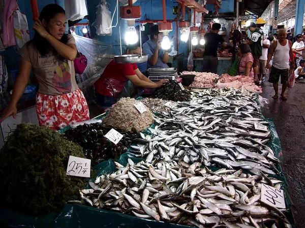 Un venditore vende pesce fresco e altri frutti di mare in un negozio in un mercato pubblico . — Foto Stock