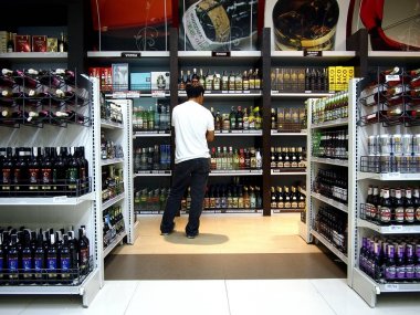 Çeşitli alkollü içecekler'ndeki bir bakkal müşterim bakar.