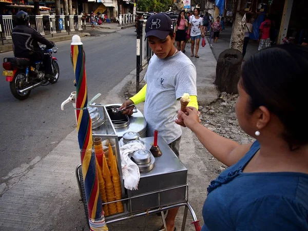 Un vendedor ambulante de comida sirve helado a un cliente . — Foto de Stock