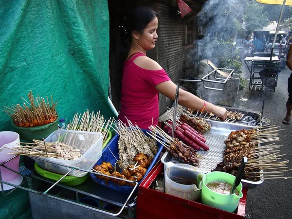 A street food vendor grills assorted snack items which includes chicken innards. — Stock Photo, Image