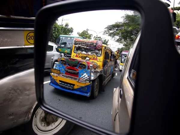 Ein farbenfroher Jeepney aus dem Seitenspiegel eines Autos. — Stockfoto