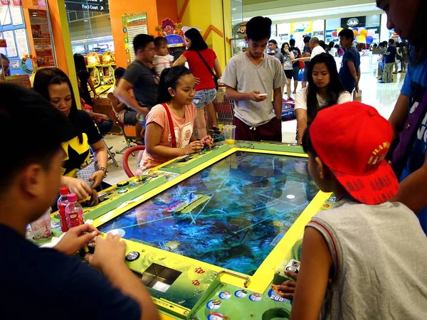 I clienti apprezzano i diversi giochi e attrazioni all'interno di una sala giochi in un centro commerciale . — Foto Stock