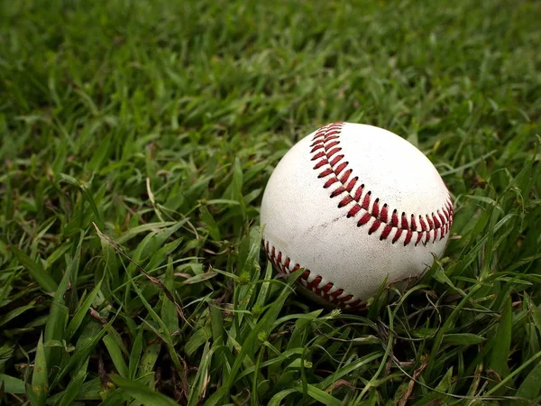 Beisebol em um campo de grama — Fotografia de Stock