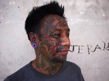 Vücut sanatı olan bir adam onun yüz dövme ve piercing kulak gösterir.