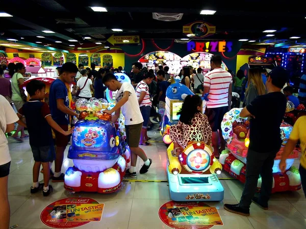 Customers inside a gaming or amusement arcade enjoy the different attractions and video games. — Stock Photo, Image