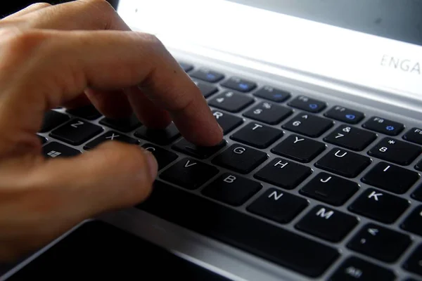 Mano en un teclado de ordenador portátil — Foto de Stock