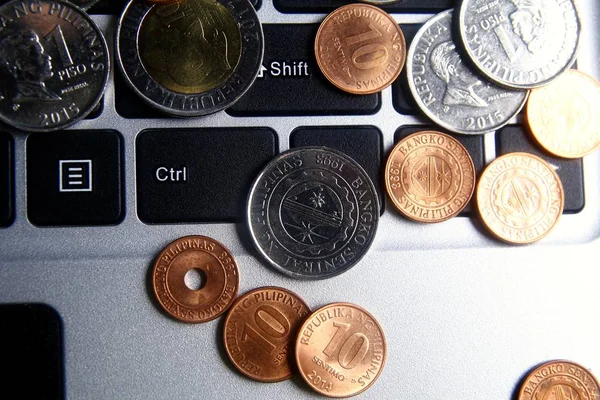 Monedas en un teclado de computadora portátil — Foto de Stock