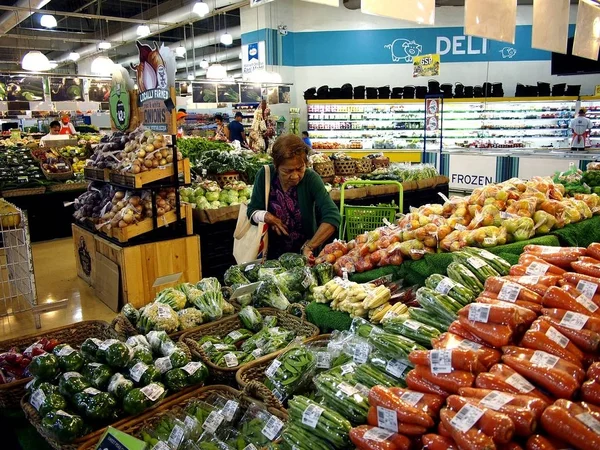 Un cliente sceglie tra un'ampia varietà di verdure fresche in un negozio di alimentari . — Foto Stock