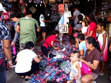 Müşteriler bakın ve farklı çocuk ayakkabı bir at arasında seçmek shift mağaza tarafından bir kaldırım.