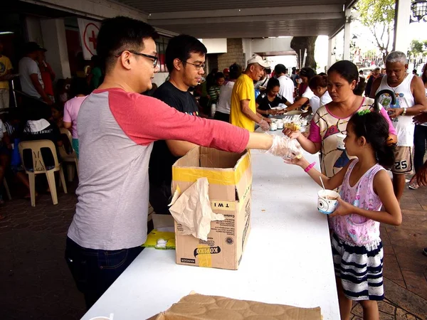 Volunteers give out food during a feeding program at a church. — Stock Photo, Image