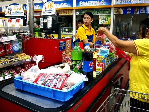 A pénztáros részt vesz, hogy egy ügyfél egy élelmiszerbolt. — Stock Fotó