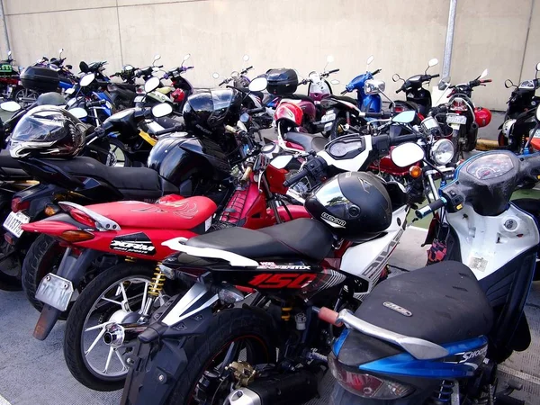 Motorkerékpárok és robogók parkolt egy parkolóban egy bevásárlóközpont. — Stock Fotó