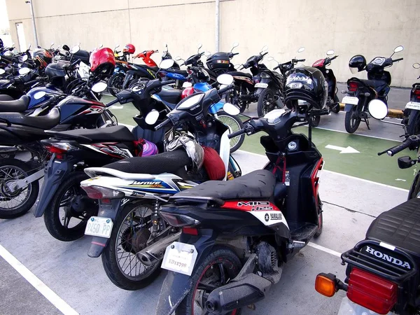 Motorfietsen en scooters geparkeerd op een parkeerplaats van een winkelcentrum. — Stockfoto