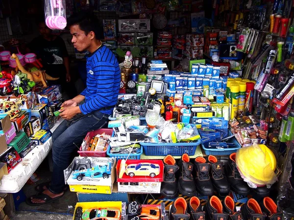 Majitel obchodu sedí uvnitř svého obchodu při čekání na zákazníky, aby kupovali mezi jeho širokou škálu výrobků. — Stock fotografie