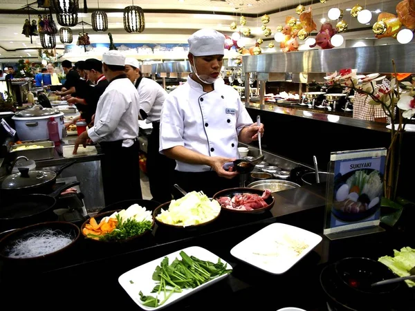 Um chef serve comida acabada de cozinhar para um cliente em um restaurante . — Fotografia de Stock