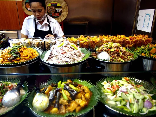 Berbagai hidangan Filipina dipamerkan di kios makanan di sebuah food court di sebuah pusat perbelanjaan . — Stok Foto