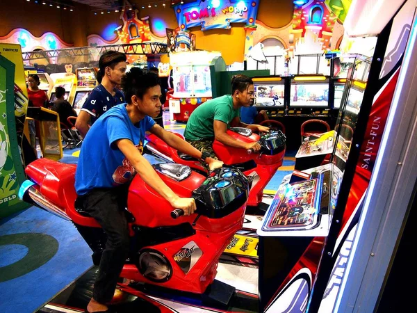 I clienti apprezzano i diversi giochi e attrazioni all'interno di una sala giochi all'interno di un centro commerciale . — Foto Stock