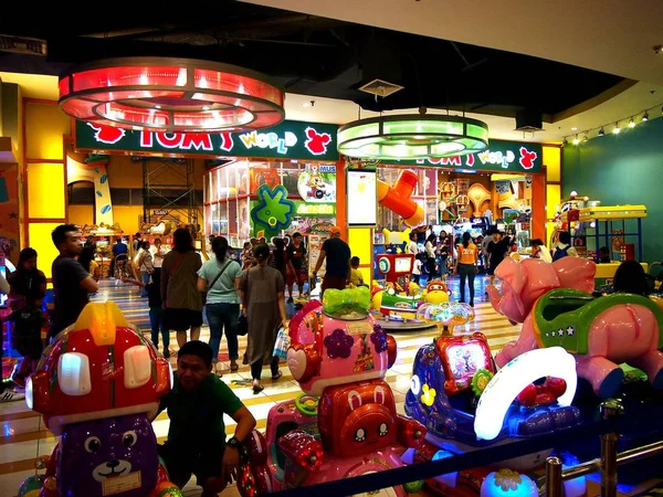 Los clientes disfrutan de los diferentes juegos y atracciones dentro de una galería de atracciones dentro de un centro comercial . — Foto de Stock