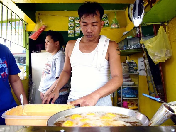 Een man diep frietjes eend eieren in een beslag van meel in zijn voedsel-kiosk — Stockfoto