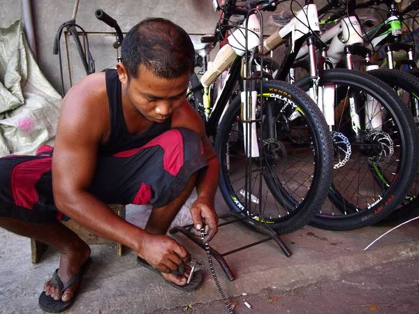 Ремонтник велосипедов чинит велосипедную цепочку в магазине велосипедов . — стоковое фото