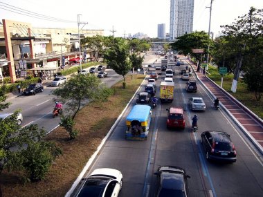 Araç geçmek boyunca bir genellikle sıkışık trafik Katipunan Avenue Quezon City, Filipinler.