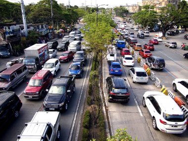 Araç geçmek boyunca bir genellikle sıkışık trafik Katipunan Avenue Quezon City, Filipinler.