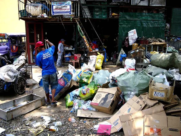 Pekerja di sebuah toko sampah atau fasilitas pemulihan material memilah-milah semua jenis bahan daur ulang . — Stok Foto