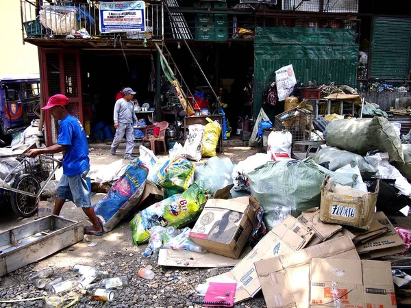 Pekerja di sebuah toko sampah atau fasilitas pemulihan material memilah-milah semua jenis bahan daur ulang . — Stok Foto