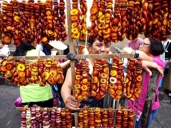 Bir sokak satıcısı kurutulmuş sonsuz çiçeklerin renkli çelenk satıyor. — Stok fotoğraf