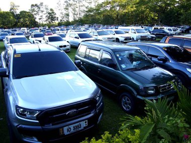 Çok sıkı bir şekilde bir çok büyük çim alanda park etmiş arabalar.