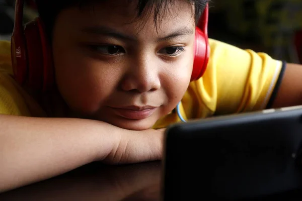 Junger asiatischer Junge mit Smartphone und Kopfhörer — Stockfoto