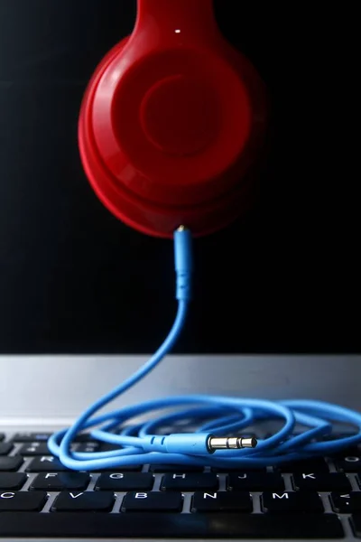 Cable of stereo headphones and a laptop computer — Stock Photo, Image